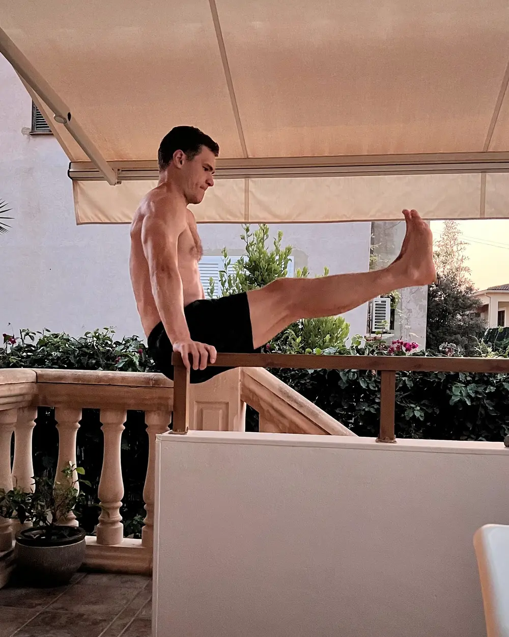 Nils im L-Sitz auf einem Terrassengeländer